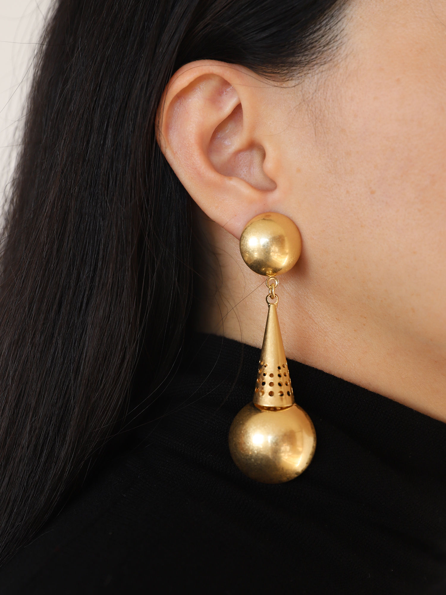 The golden frosted ball earrings have a matte and hazy surface, which